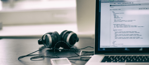 Headphones cards and a open laptop on a desk.